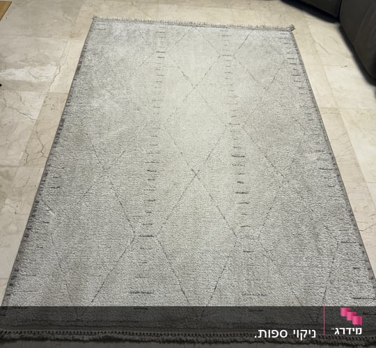 שטיח בהיר על רצפת שיש ליד ספה כהה